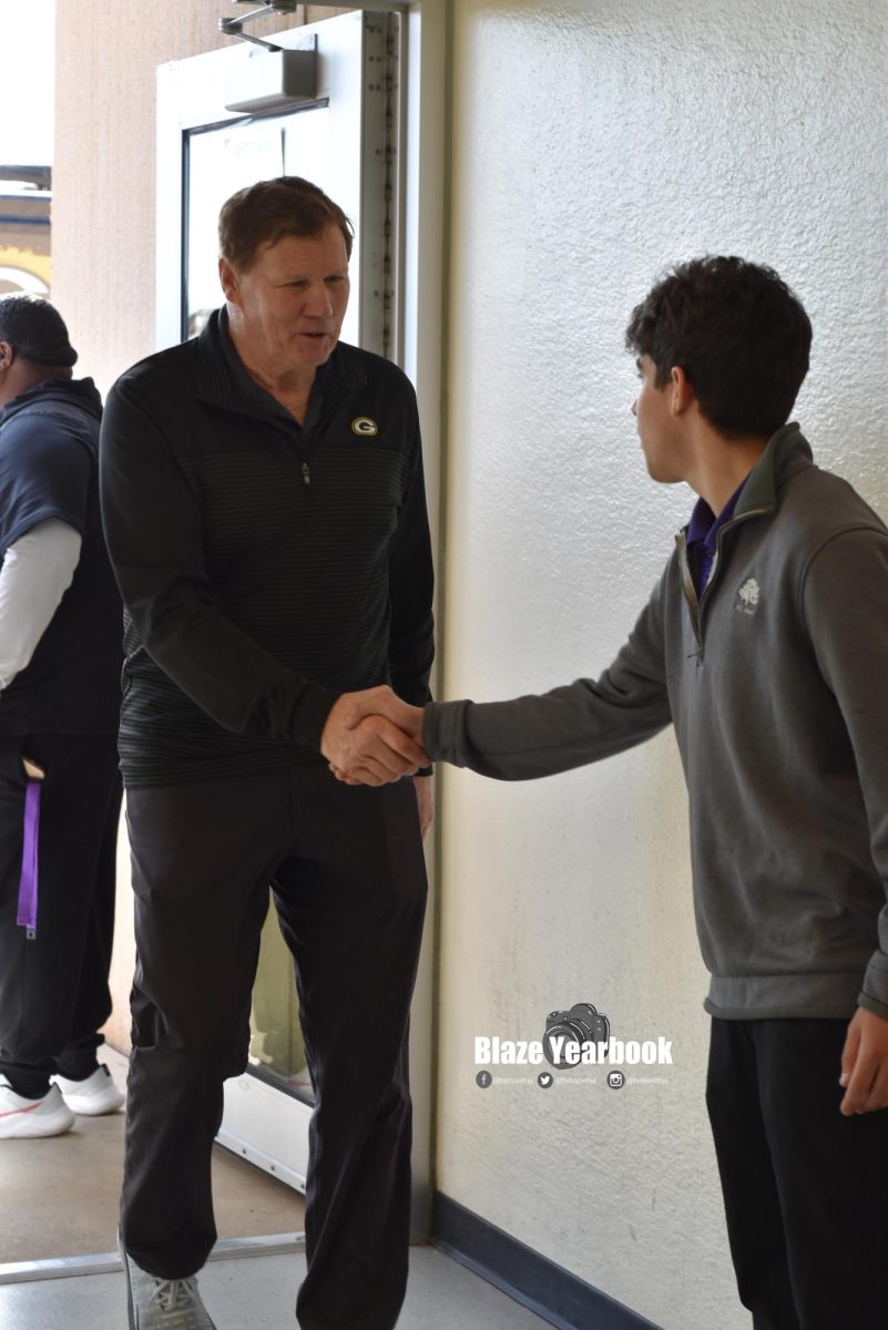 Mark Murphy, Packers CEO/President, shakes hands with Hawk Hustle podcast co-host Matt Ross (12) as he enters the school.