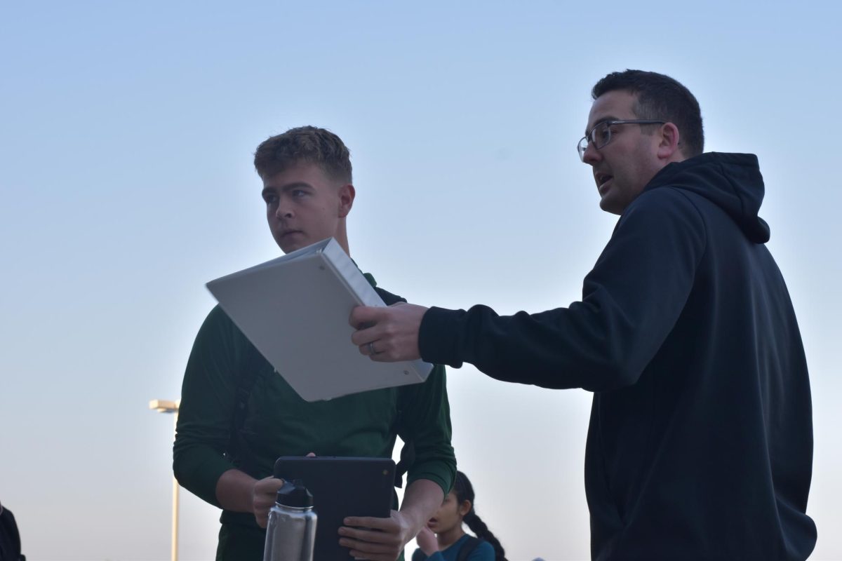 Looking for clarification on the new rules, Caden George (12) consults with Nicholas Myers for an explanation on the first day of metal detectors.
